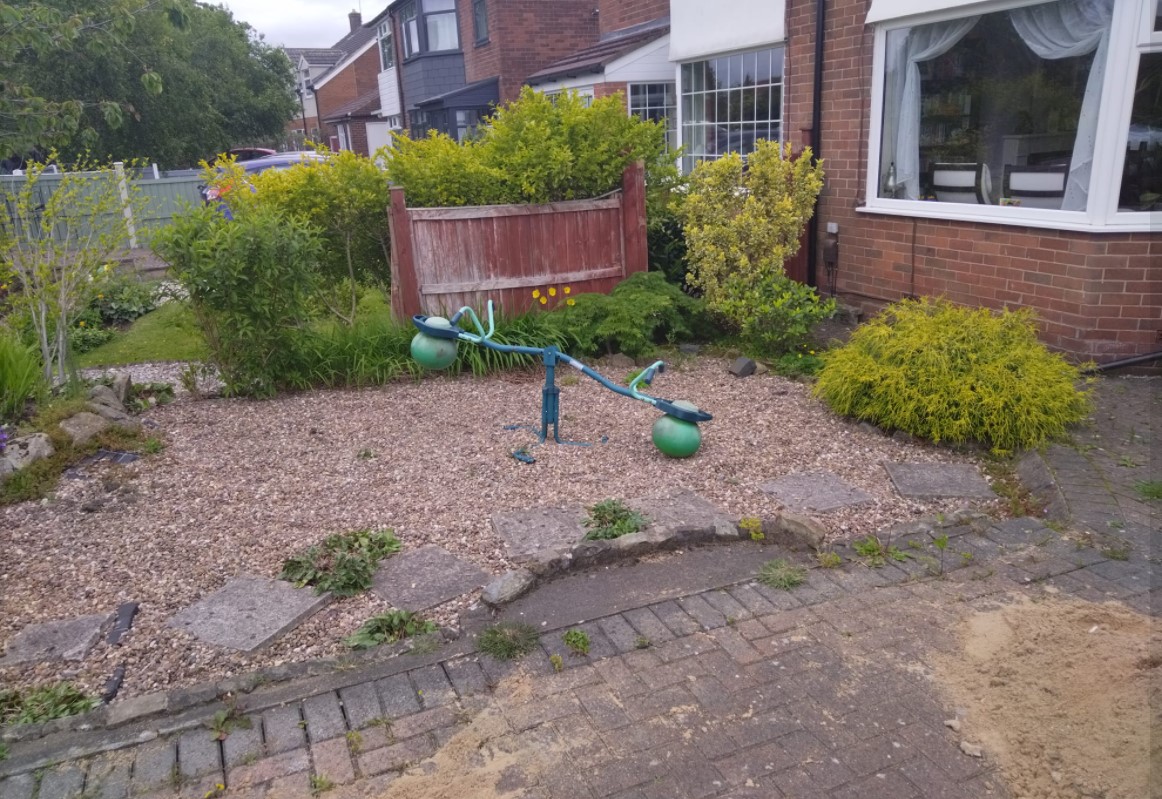 The front garden before work, with gravel, old planting and a low fence
